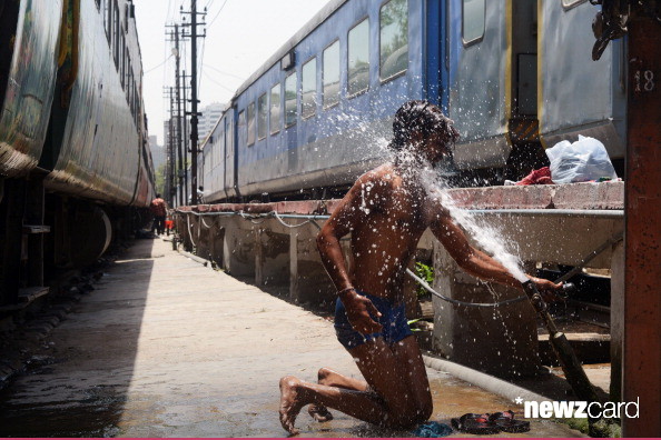 An Indian man washes himself at a water pipe to cool down at a railway station in New Delhi on May 22, 2013. Heatwave conditions continued in the Indian capital, with temperatures registering a record high for the month of May at 45.6 degrees celsius. AFP PHOTO/RAVEENDRAN (Photo credit should read RAVEENDRAN/AFP/Getty Images)